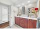 Dual vanity bathroom featuring wood cabinets, quartz countertop, and ample natural light at 1220 Pinellas Point S Dr, St Petersburg, FL 33705
