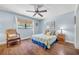 Comfortable bedroom with a large window, ceiling fan, hardwood floors and a cozy reading chair at 1220 Pinellas Point S Dr, St Petersburg, FL 33705