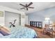 Bedroom featuring hardwood floors, ceiling fan, comfortable chair and bookshelf display at 1220 Pinellas Point S Dr, St Petersburg, FL 33705