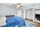 Bedroom featuring ceiling fan, light blue walls, hardwood floors, closet and ensuite bathroom access at 1220 Pinellas Point S Dr, St Petersburg, FL 33705
