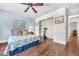 Bedroom with hardwood floors, ceiling fan, and attached shelving unit for storage and display at 1220 Pinellas Point S Dr, St Petersburg, FL 33705