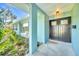 Inviting front entry with a welcome mat, unique architectural details, and shade-providing portico at 1220 Pinellas Point S Dr, St Petersburg, FL 33705