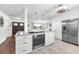 Kitchen island with stainless appliances and cooktop; lots of storage with white cabinetry at 1220 Pinellas Point S Dr, St Petersburg, FL 33705