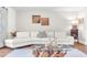 Close up of living room with white sofa, hardwood floors, and unique coffee table at 1220 Pinellas Point S Dr, St Petersburg, FL 33705