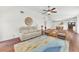 Bright living room featuring a ceiling fan, hardwood floors and blue, cream and yellow accent rug at 1220 Pinellas Point S Dr, St Petersburg, FL 33705