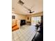 Living room with ceiling fan, tile flooring and a sliding glass door leading to the backyard at 12367 Foxmoor Peak Dr, Riverview, FL 33579