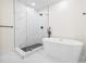 Modern bathroom with a freestanding tub and glass-enclosed shower with black hardware at 1323 48Th N Ave, St Petersburg, FL 33703