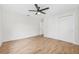 Bedroom with wood-look floors, neutral paint, ceiling fan and closet with sliding doors at 1323 48Th N Ave, St Petersburg, FL 33703
