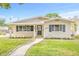 Charming single-story home features a well-manicured lawn, inviting walkway, and freshly painted exterior at 1323 48Th N Ave, St Petersburg, FL 33703