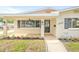 Covered front porch featuring a ceiling fan, black door, and manicured landscaping at 1323 48Th N Ave, St Petersburg, FL 33703