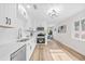 Bright, modern kitchen features white cabinets, stainless steel appliances, and hardwood flooring at 1323 48Th N Ave, St Petersburg, FL 33703