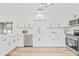 Modern kitchen boasts white cabinets, stainless steel appliances, and hardwood flooring at 1323 48Th N Ave, St Petersburg, FL 33703