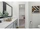 Bathroom with double vanity, framed mirror, and view of closet at 1497 Laredo Ave, Spring Hill, FL 34608