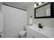 Bright bathroom featuring a white vanity, black hardware, and a shower with a patterned curtain at 14984 Cromwell Dr, Clearwater, FL 33764