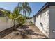A glimpse of the property's yard featuring privacy fence, tropical plants, and outdoor shower at 1702 E Knollwood St, Tampa, FL 33610