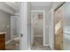 Bathroom area featuring neutral colors, tile floors, a toilet, and access to a shower behind a glass door at 1702 E Knollwood St, Tampa, FL 33610