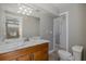 Bright bathroom with a marble countertop, decorative wood vanity, and access to the updated shower at 1702 E Knollwood St, Tampa, FL 33610