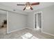 Neutral bedroom featuring tile floors, a ceiling fan, and access to a bathroom and possible closet space at 1702 E Knollwood St, Tampa, FL 33610