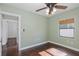 Bedroom featuring hardwood floors, a ceiling fan, window with wooden blinds, and a closet at 1702 E Knollwood St, Tampa, FL 33610