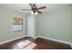 Bedroom featuring hardwood floors, a ceiling fan, and window with wooden blinds at 1702 E Knollwood St, Tampa, FL 33610