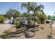 Residential home with tropical foliage, gravel driveway, and white exterior at 1702 E Knollwood St, Tampa, FL 33610