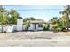Charming white home featuring a cozy entryway, palm trees, and a striking chimney design at 1702 E Knollwood St, Tampa, FL 33610