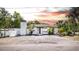 Charming white home featuring a cozy entryway, palm trees, and a striking chimney design at 1702 E Knollwood St, Tampa, FL 33610