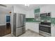 Modern kitchen featuring white cabinetry, stainless steel appliances, and subway tile at 1702 E Knollwood St, Tampa, FL 33610