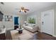 Bright living room features hardwood floors, neutral paint, ceiling fan, and plenty of natural light at 1702 E Knollwood St, Tampa, FL 33610