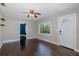 Unstaged living room featuring hardwood flooring, a ceiling fan, and a large window at 1702 E Knollwood St, Tampa, FL 33610