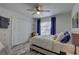 Serene bedroom with large closet, ceiling fan, window with blue curtains, and wood-look flooring at 222 Draw Bridge Ln, Valrico, FL 33594