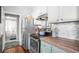 Stylish kitchen showcasing stainless steel appliances, contrasting cabinets, and updated counters, leading to the bathroom at 2235 Burlington N Ave, St Petersburg, FL 33713