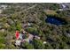 An aerial view shows the property surrounded by lush trees and a picturesque lake with a fountain feature at 2627 2Nd Ct, Palm Harbor, FL 34684