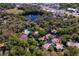 An aerial shot shows the property within a tree-filled community with amenities like a pool, tennis court, and scenic pond at 2627 2Nd Ct, Palm Harbor, FL 34684