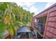 Cozy balcony with a tile roof and view of lush tropical landscaping and a patio at 2627 2Nd Ct, Palm Harbor, FL 34684