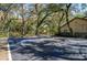 A basketball court surrounded by large trees and foliage with the buildings in the background at 2627 2Nd Ct, Palm Harbor, FL 34684