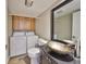 Bathroom featuring a vessel sink, mirror, toilet and washer/dryer at 2627 2Nd Ct, Palm Harbor, FL 34684