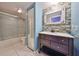 Updated bathroom with a modern vanity, decorative mirror, and a sleek glass-enclosed shower at 2627 2Nd Ct, Palm Harbor, FL 34684