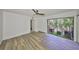 A spacious bedroom with wood-look floors and a private balcony offering natural light and outdoor views at 2627 2Nd Ct, Palm Harbor, FL 34684