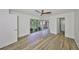 A bright, open bedroom featuring wood-look floors, a ceiling fan, and a sliding glass door to a private balcony at 2627 2Nd Ct, Palm Harbor, FL 34684