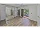 Bright bedroom with wood-look floors, ceiling fan, sliding mirrored closet, and a private balcony overlooking lush greenery at 2627 2Nd Ct, Palm Harbor, FL 34684