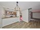 Dining area with wood-look floors, decorative lighting, kitchen pass-through, and access to outdoor area at 2627 2Nd Ct, Palm Harbor, FL 34684