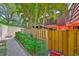 View of a two-story townhome with a patio, gazebo, balcony, and tropical landscaping at 2627 2Nd Ct, Palm Harbor, FL 34684