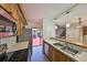Kitchen with stainless steel appliances, wood cabinets, bar seating, and access to the dining and outdoor area at 2627 2Nd Ct, Palm Harbor, FL 34684