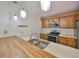 Galley kitchen featuring stainless steel appliances, wooden cabinets, and a breakfast bar with a sink at 2627 2Nd Ct, Palm Harbor, FL 34684