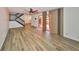 Spacious living room with wood-look flooring, a ceiling fan, access to the entry and a private patio at 2627 2Nd Ct, Palm Harbor, FL 34684