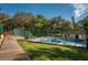 Community pool and lounge area surrounded by lush greenery and a fenced-in perimeter at 2627 2Nd Ct, Palm Harbor, FL 34684