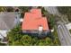 Aerial view of a well-maintained home with a red roof and screened-in pool area surrounded by lush greenery at 2701 W Bay Ave, Tampa, FL 33611
