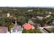 Aerial view showcases a neighborhood with mature trees and a peek of the waterfront and city skyline at 2701 W Bay Ave, Tampa, FL 33611