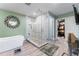 Main bathroom with a glass shower, soaking tub, decorative mirror and entrance to a closet at 2701 W Bay Ave, Tampa, FL 33611